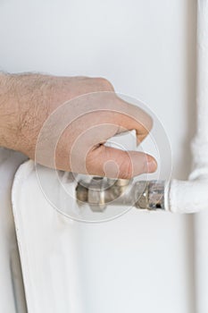 Male hand adjusting thermostat.