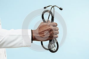 The male hand of afro american doctor on blue background