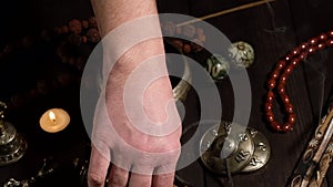Male hand arranges religious items of prayers and meditations on the table