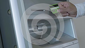 Male hand attaching the card to the atm machine, withdrawing money from account. Hdr. automatic machine for cash