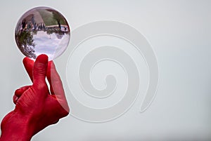 Male hand balancing glass sphere with space on right for caption