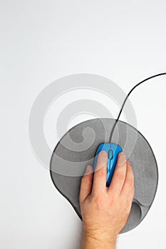 Male hand with blue computer mouse and pad on white background