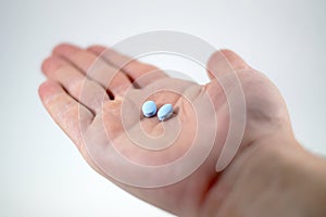 Male hand with blue pills