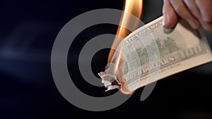 Male hand burning dollar banknote. Man burning money cash. Financial crisis