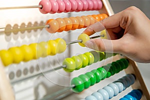 Male hand calculating beads on rainbow abacus