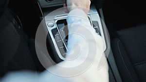 Male hand changing gear driving car. Driver man controls auto and switch gears, then shifts to neutral gear and pulls