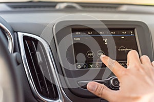 Male hand changing the radio station on car LCD infotainment screen