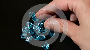 Male hand check quality of blue diamonds or gemstone