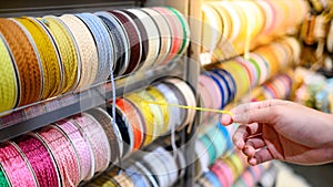 Male hand choosing Ric Rac ribbon in craft shop