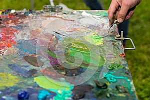 Male hand cleaning off a palette with paletteknife