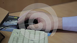 Male hand clicking computer mouse
