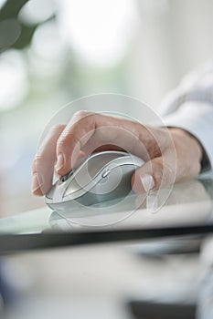 Male hand clicking a cordless computer mouse on a green table