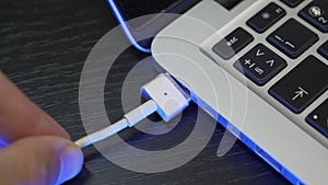 Male hand is connecting laptop charger. Laptop computer with USB type C connector for charger