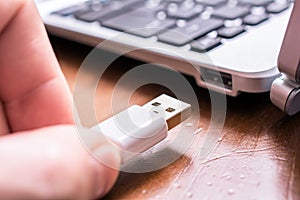 Male Hand Connecting A White USB Cable To The USB Port Of A Small Keyboard