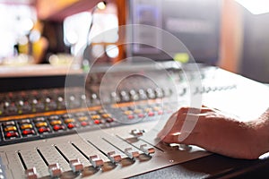 Male hand on control Fader on console. Sound recording studio mixing desk with engineer or music producer