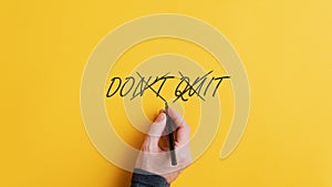 Male hand crossing off a Don`t quit sign to change it into a Do it message