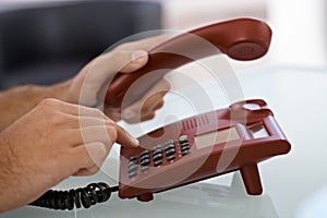 Male hand dial on landline phone photo