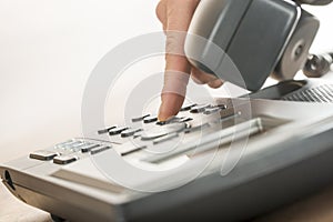 Male hand dialing a classical landline telephone