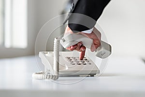 Male hand dialing a telephone number in order to make a phone ca