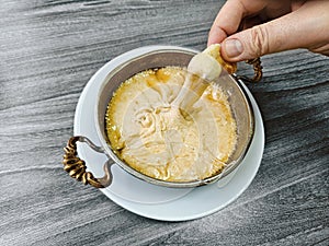 Male hand dipping bread to traditional Turkish meal called Mihlama or Kuymak served in a hot pan