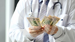 Male hand of doctor hald dollar cash in hand