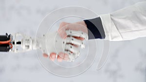 Male hand of doctor prosthetist shakes hand robotic prosthesis in medical center