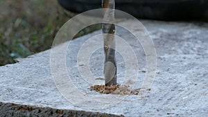 Male hand drilling wood with manual drilling machine outdoors in the autumn close up view