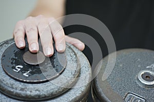Male hand on dumbbell weight