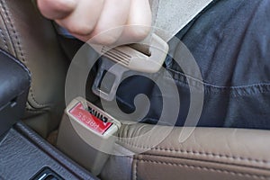 Male hand fastens the seat belt in the car close-up.
