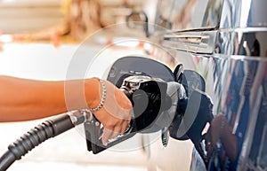 Male hand fill up petrol tank gasoline fuel petrol in car being filled with fuel at gas petrol station
