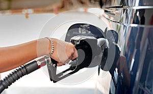 Male hand fill up petrol tank gasoline fuel petrol in car being filled with fuel at gas petrol station