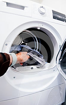 Male hand filling the washer dryer machine