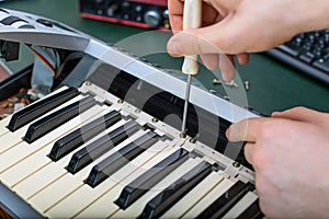 Male hand fixing midi keyboard.