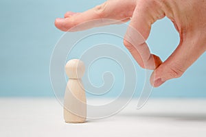 Male hand give a noogie to wooden figure
