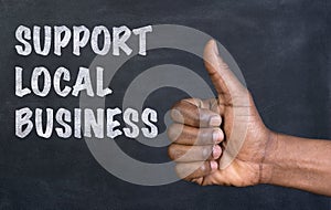 Male hand giving the thumbs up gesture to the phrase Support Local Business