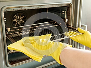 Male hand with gloves cleaning oven