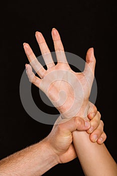 Male hand grabbing female wrist