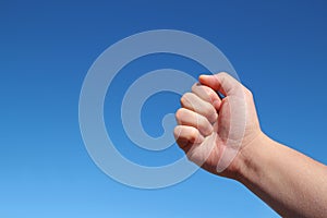 Male hand grip gesture in the blue sky