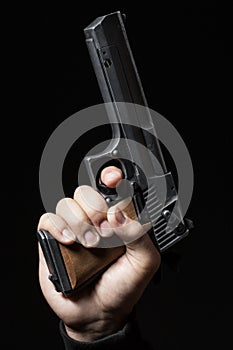 Male hand with gun isolated on black