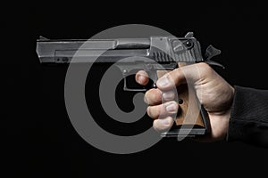 Male hand with gun isolated on black