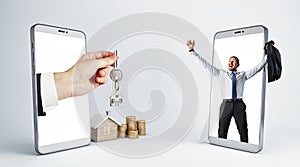 Male hand handing key from smartphone to happy european businessman with house and coins on light background. Online home purchase