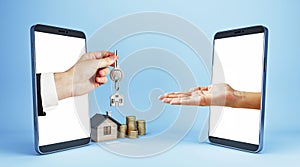 Male hand handing key from smartphone to smartphone with house and coins on blue background. Online home purchase, buy and rent