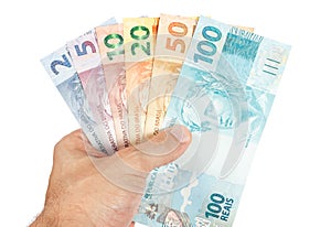 Male hand holding all brazilian reais notes photo