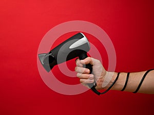 Male hand holding black hairdryer isolated on background. Hirdresser salon, barber shop, household appliances store concept