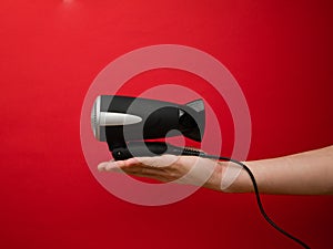 Male hand holding black hairdryer isolated on background. Hirdresser salon, barber shop, household appliances store concept