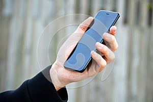 Male hand holding black smart phone
