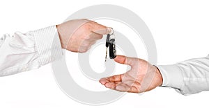 Male hand holding a car key and handing it over to another person