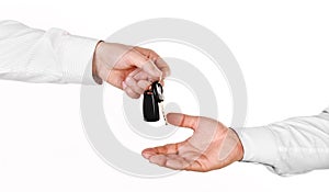 Male hand holding a car key and handing it over to another person