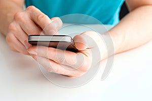 Male hand holding a cell phone and writing