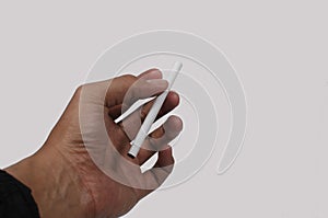 Male hand holding a cigarette on a white background isolation, copy space.